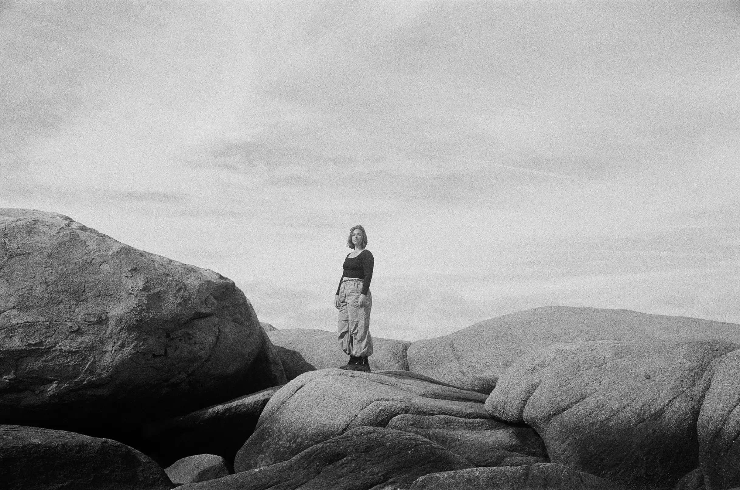 Portrait of Olive standing on large boulders